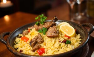 Delicious Arroz de Pato with golden rice and tender duck pieces, garnished with parsley.